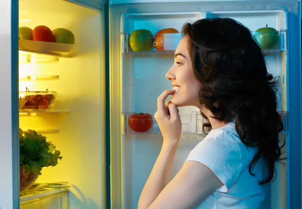 Mädchen schaut bei schnellem Gewichtsverlust in den Kühlschrank